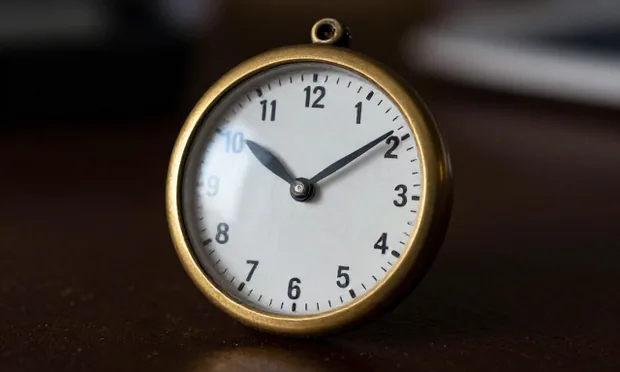 A weathered enamel instrument dial with a single black pointer, mounted in a brass bezel.