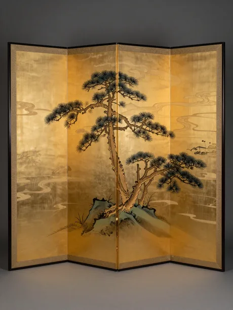 A Japanese six-fold byobu screen painted with windswept pines over a gold-leaf ground