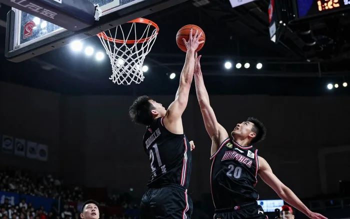 A chase-down block at the rim, both players in mid air