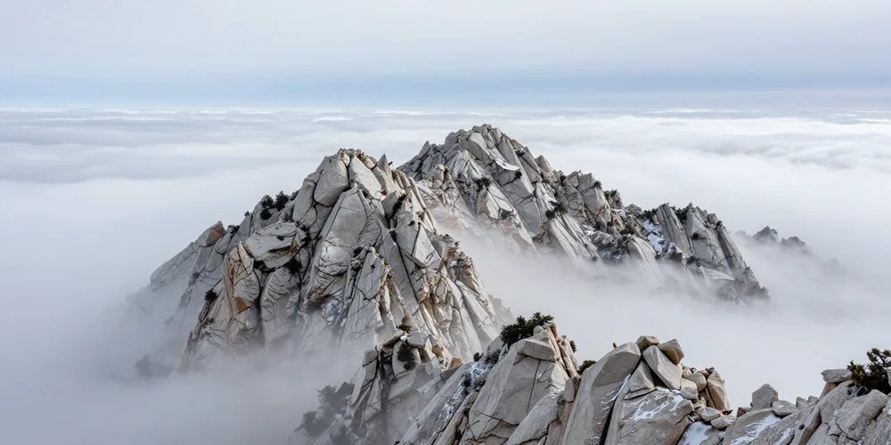 A limestone ridge rising above a sea of low cloud in flat winter light