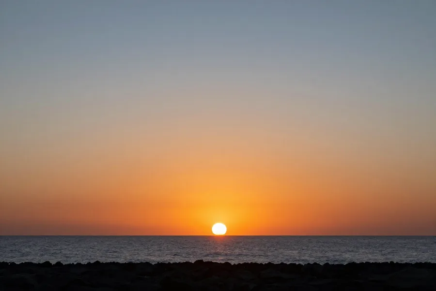 The sun gone below the sea, the sky still burning orange at the water and cooling to blue overhead.